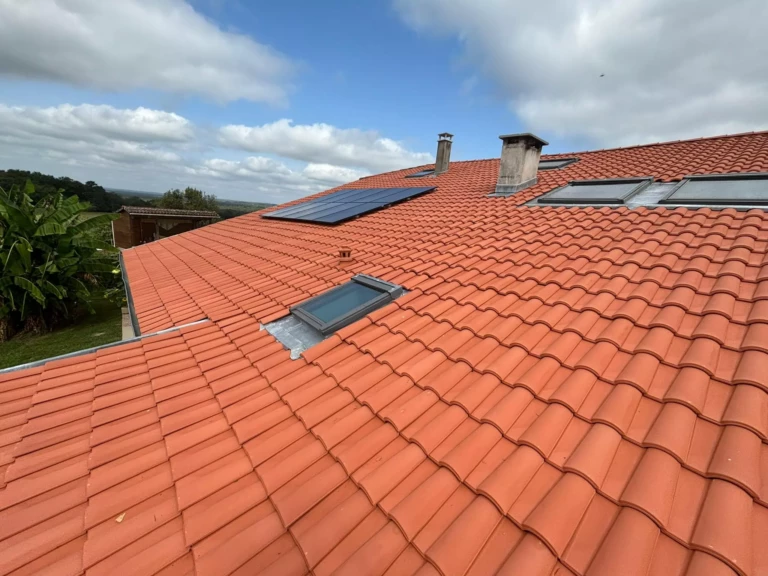 Toiture neuve en tuiles terre cuite avec fenêtres de toit et panneaux solaires intégrés